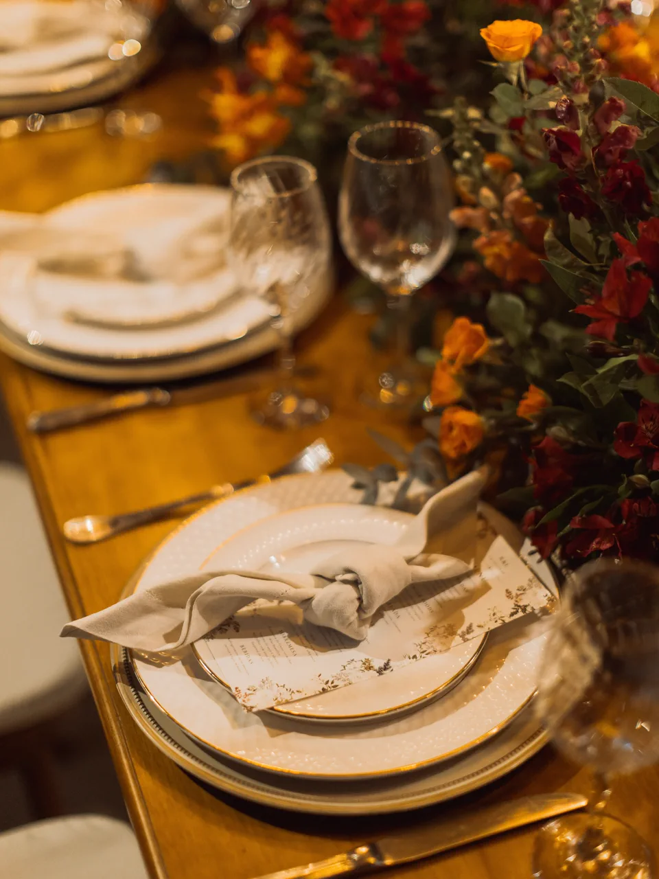 Louça, menu, guardanapo e flores em um lugar à mesa