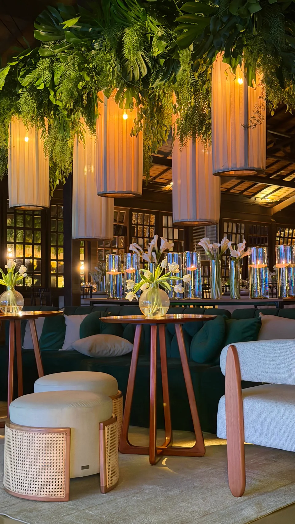Lounge interno do Sollar da Árvore com mobiliário, flores e vegetação suspensa